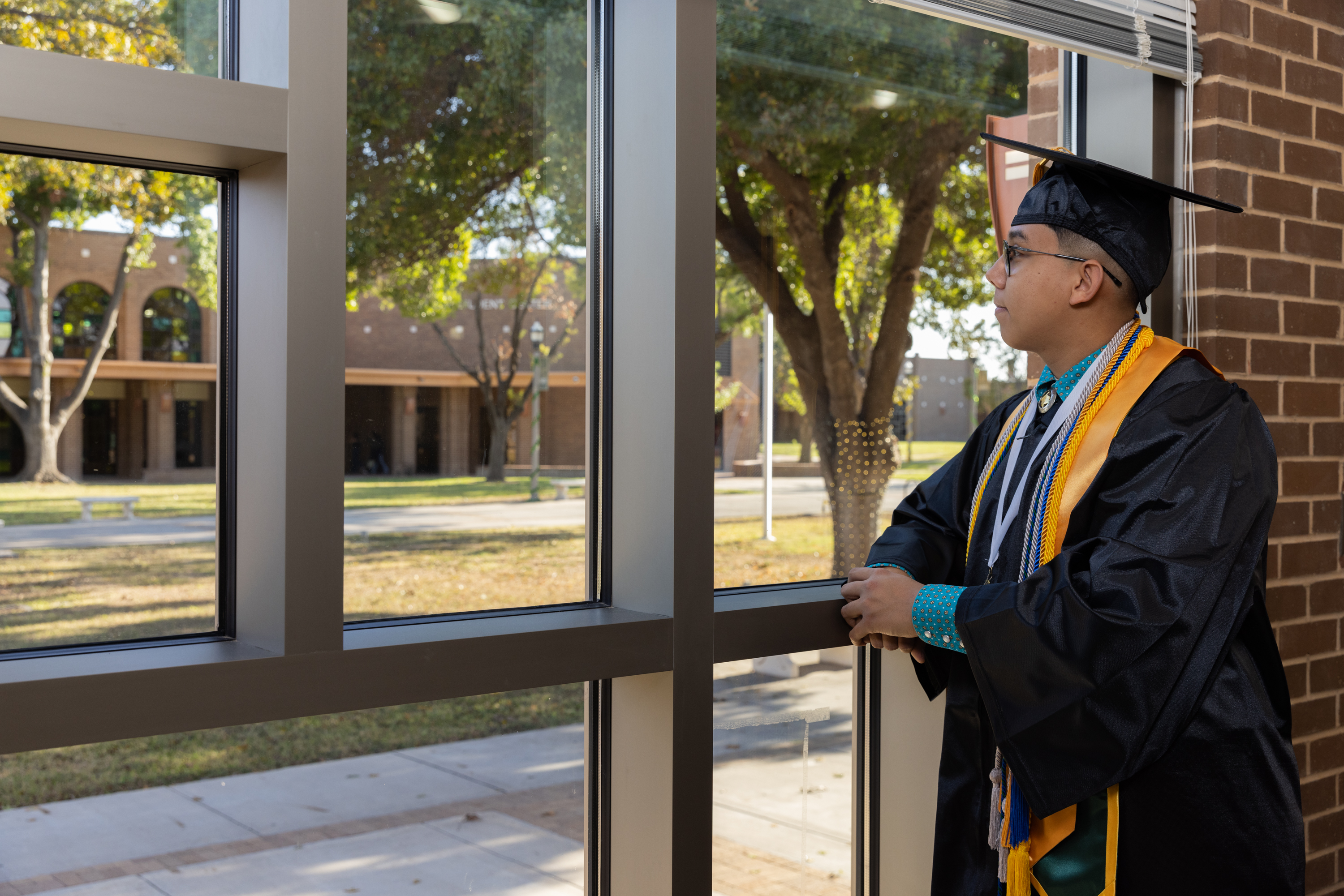 LC Graduate looks out window