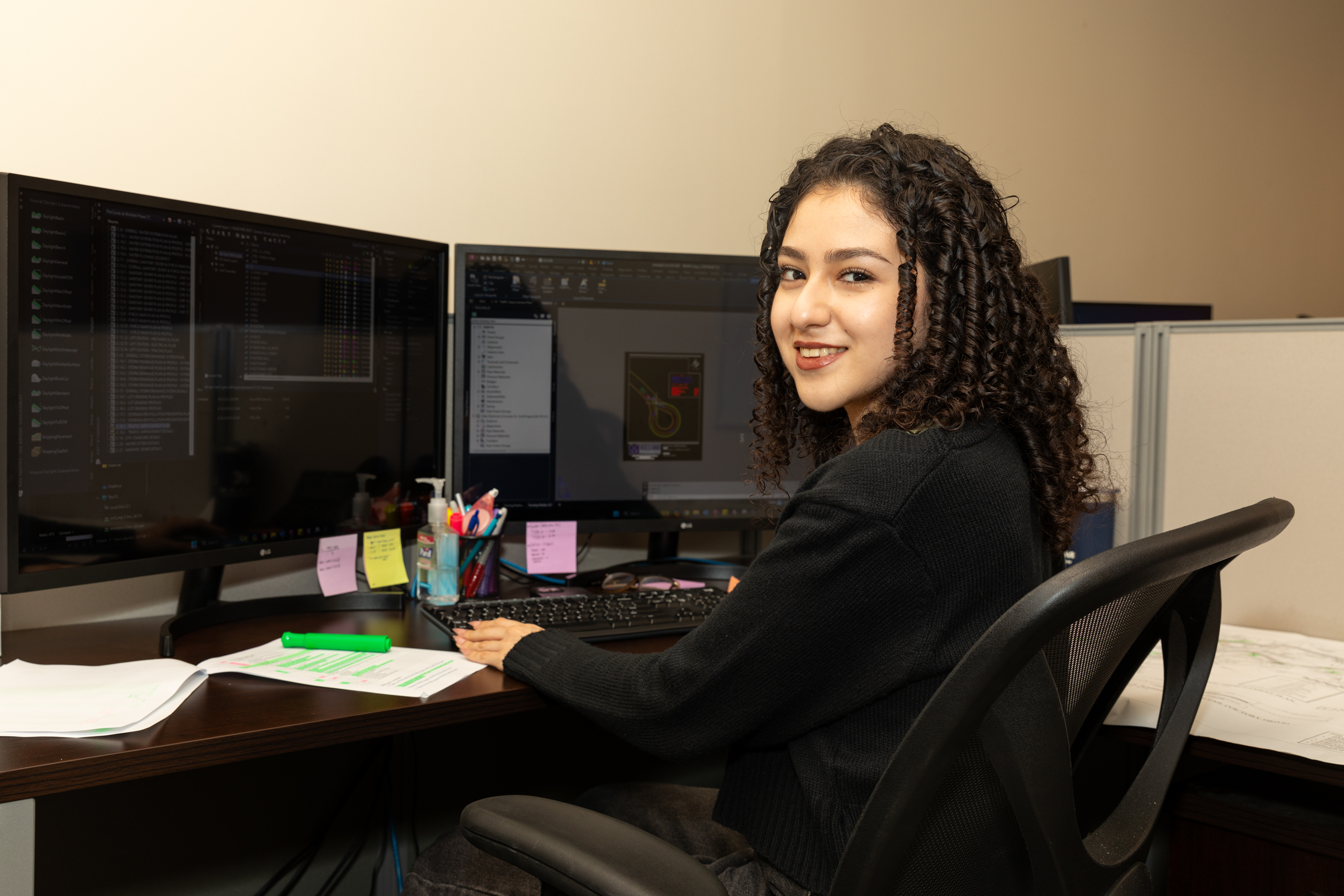 LC graduate sits at her desk