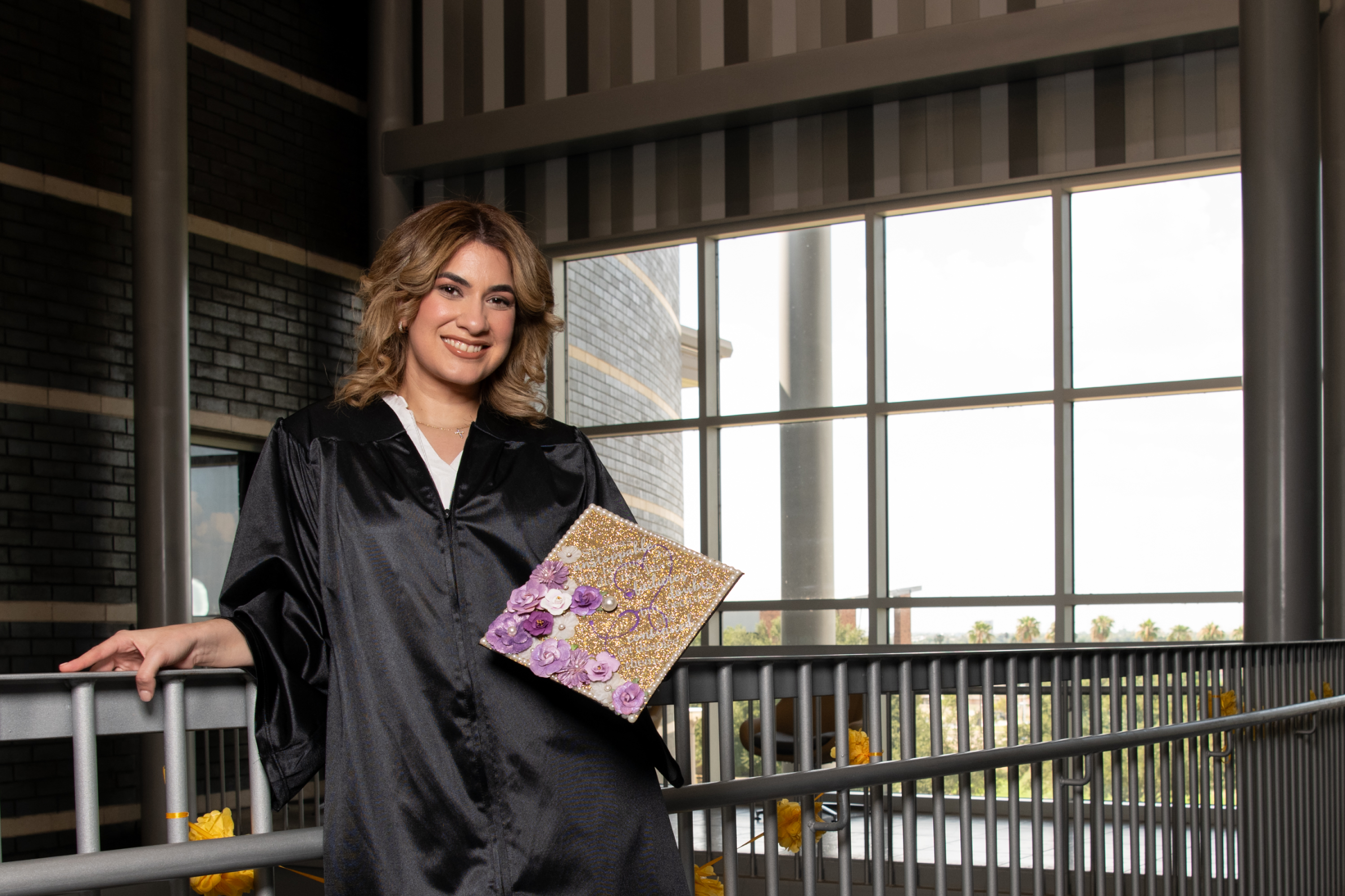 LC graduate holds cap in building