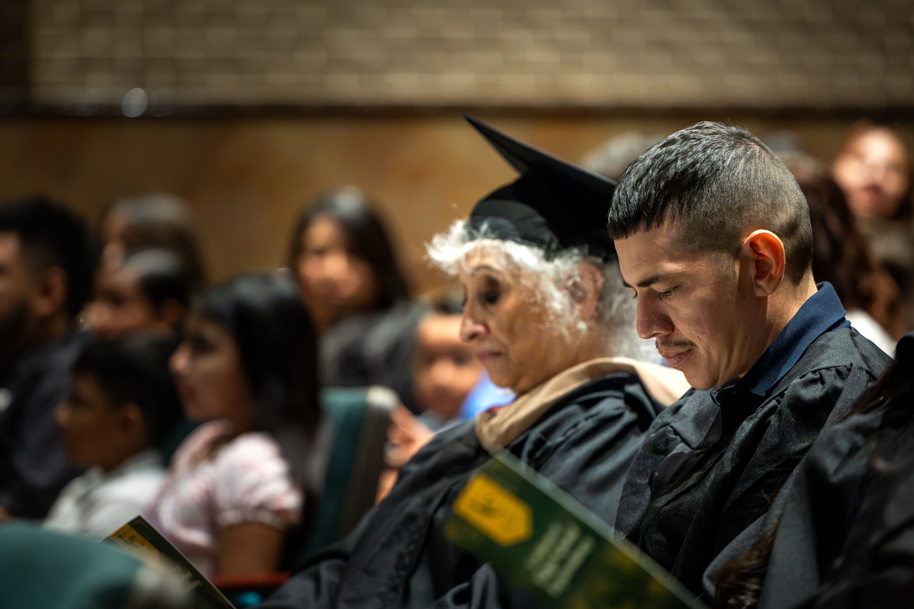 Alberto Estrada sits during GED graduation ceremony